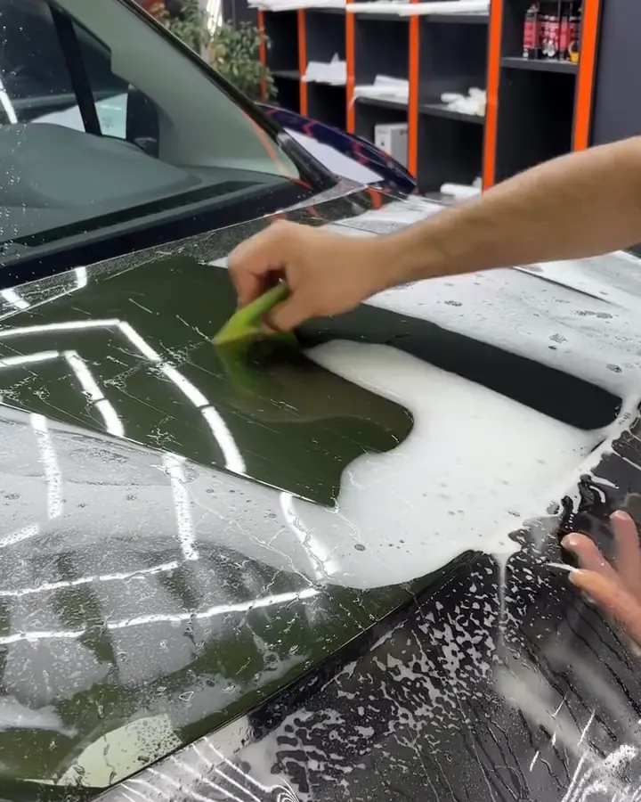 Bir Peugeot Rifter’ın kaputuna PPF film raketle uygulanırken